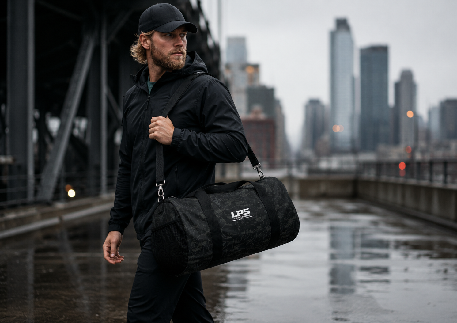Man walking with a TERRA BLACK duffel bag against an urban skyline.
